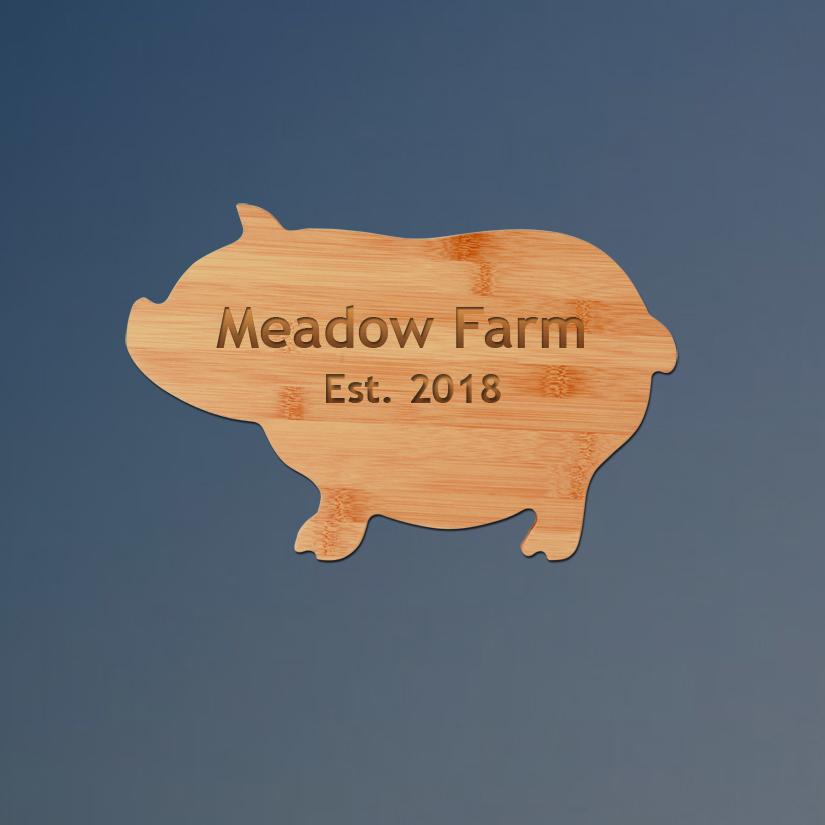Custom engraved bamboo pig cutting board with personalized text.