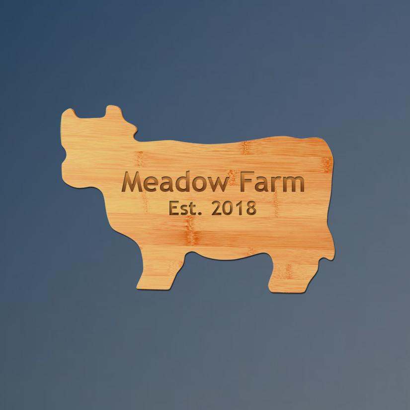 Custom engraved bamboo cow cutting board with personalized text.
