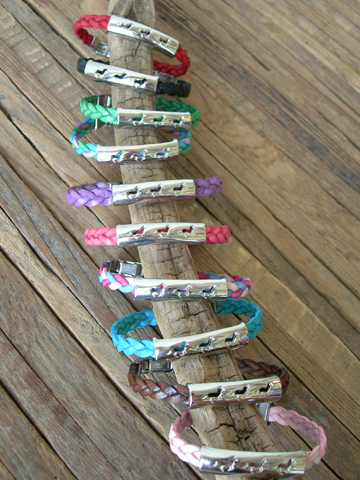 Silver sliding running pony cut design charm on a braided leather bracelet. Makes a great equestrian jewelry gift.