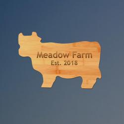 Custom engraved bamboo cow cutting board with personalized text.